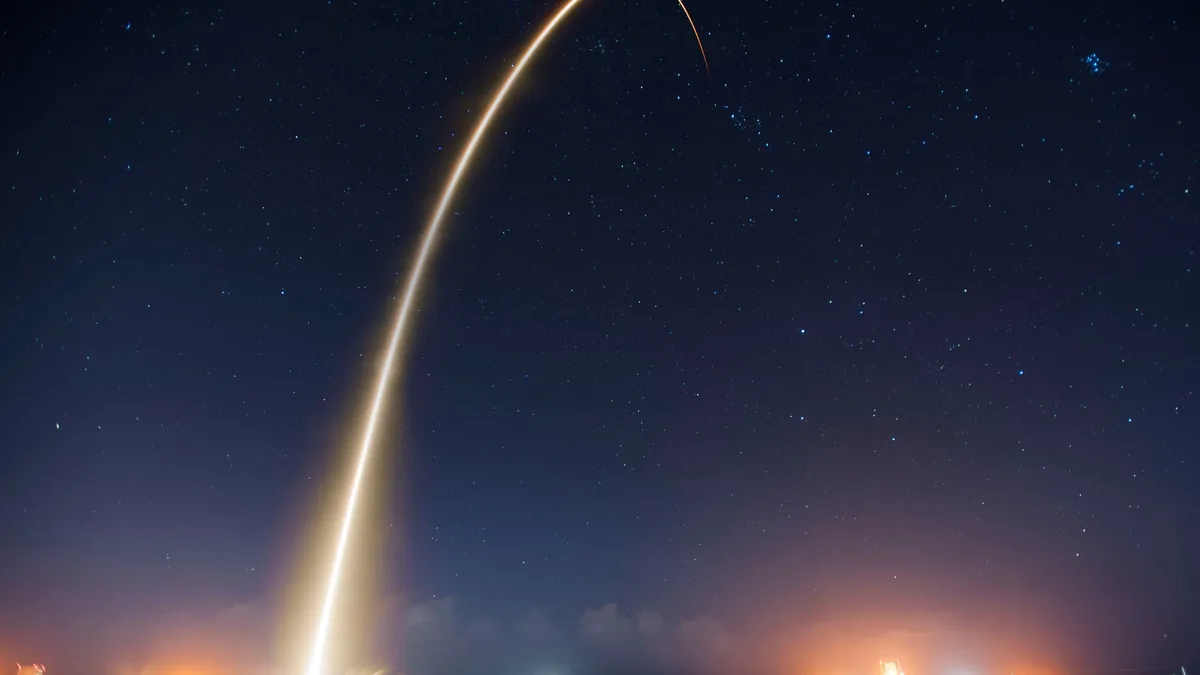 A rocket launch, with the rocket's bright light illuminating the night sky.
