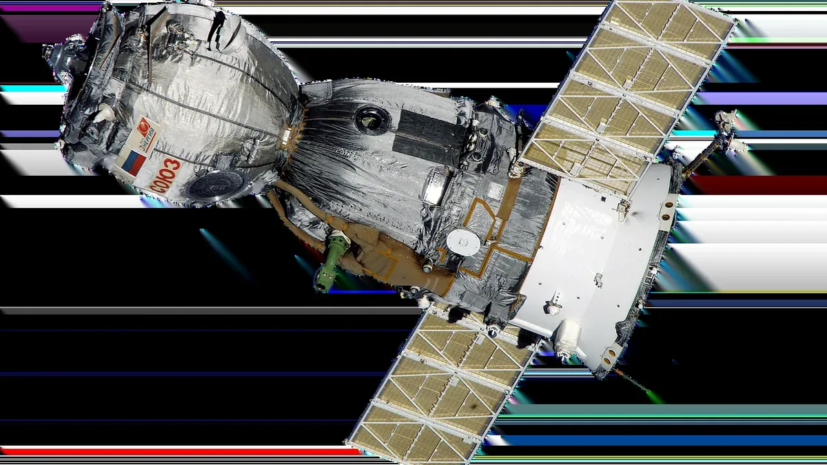 The Soyuz MS-01 spacecraft in orbit, with its solar panels and Russian flag visible.